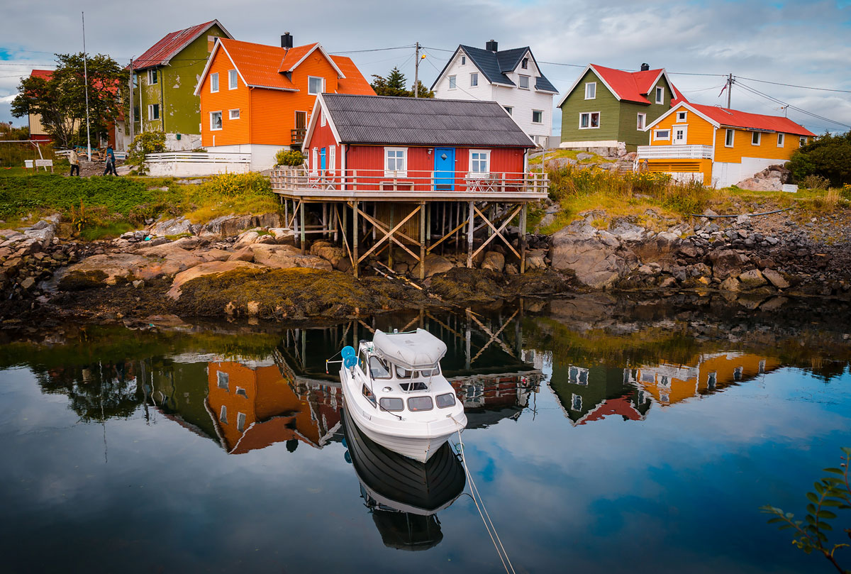 Boat in front of a red house on stilts - Henningsvaer