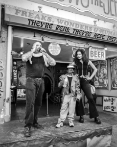 A man, a boy, and a woman on stage during a Coney island sideshow